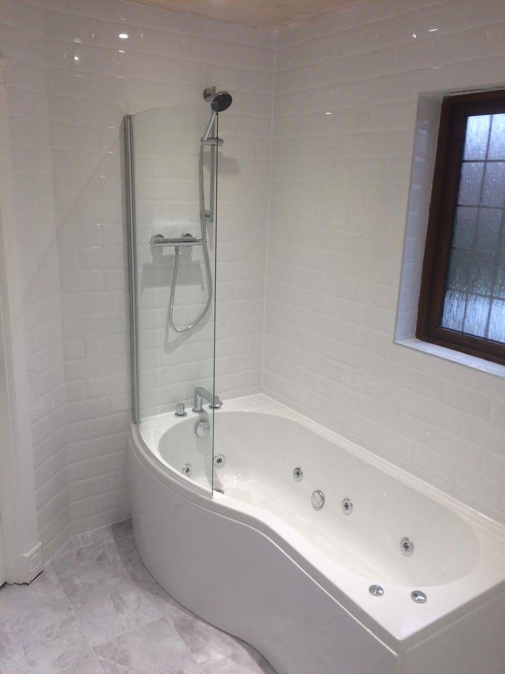 Completed tiled bathroom with spa bath and glass shower screen